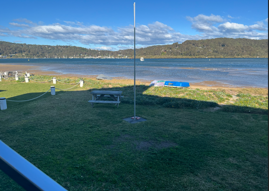 A picnic table and a pole in a grassy area by a body of water

AI-generated content may be incorrect.